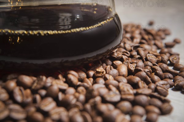 Jug of coffee on roasted coffee beans