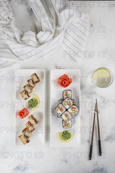 Plates of sushi with chopsticks and drinking glass