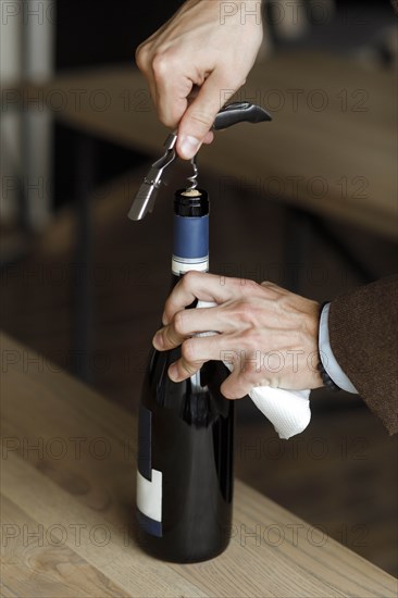 Hands of man opening bottle of wine