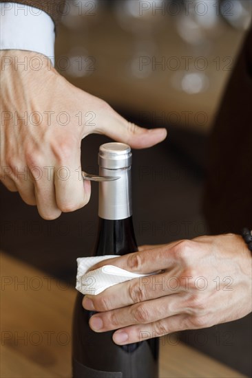 Hands of man opening bottle of wine