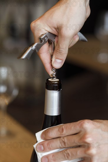 Hands of man opening bottle of wine