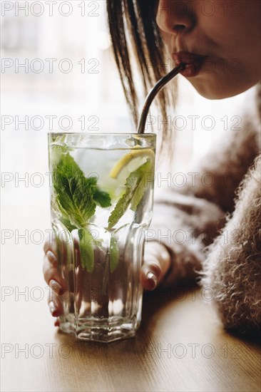 Young woman drinking cocktail