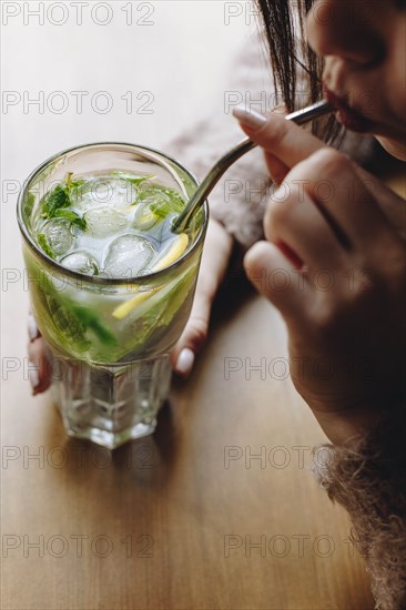 Young woman drinking cocktail