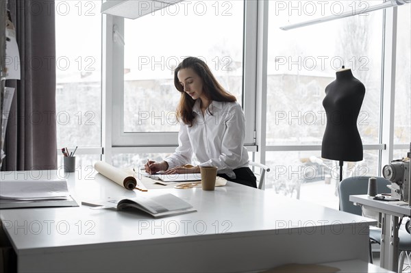 Fashion designer working at desk in studio