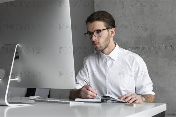 Businessman writing in note book