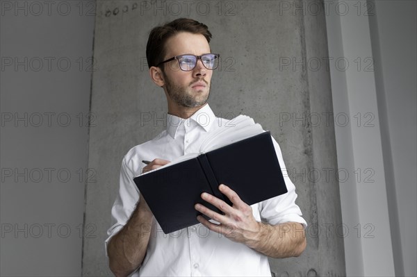 Businessman writing in note book