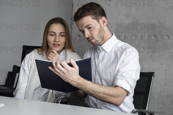 Businessman showing notebook to colleague