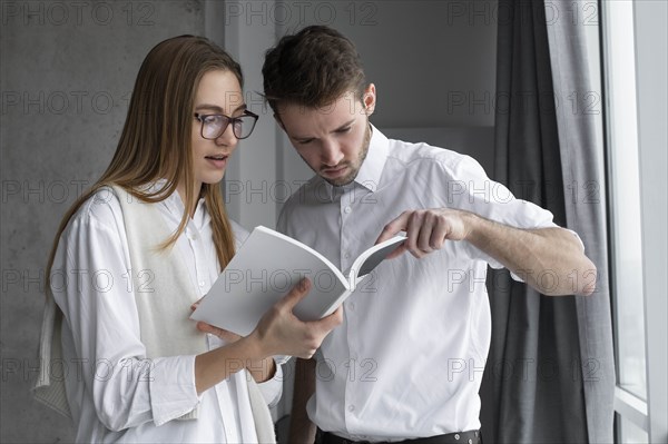 Businessman pointing to page in book for colleague
