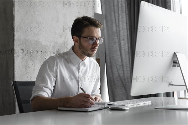 Businessman writing in notebook