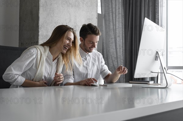 Colleagues laughing at desk