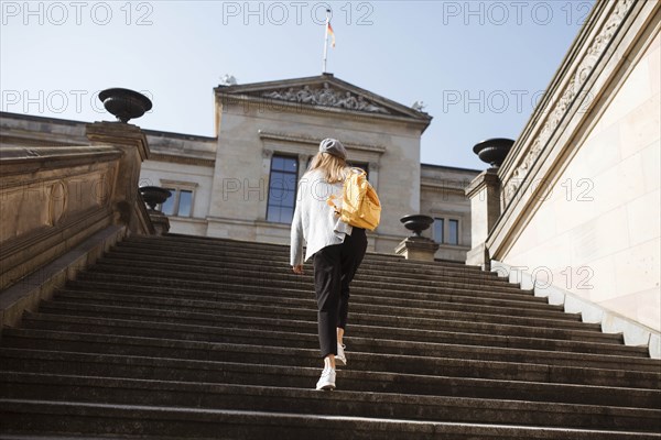 Young woman walking on steps in Berlin, Germany