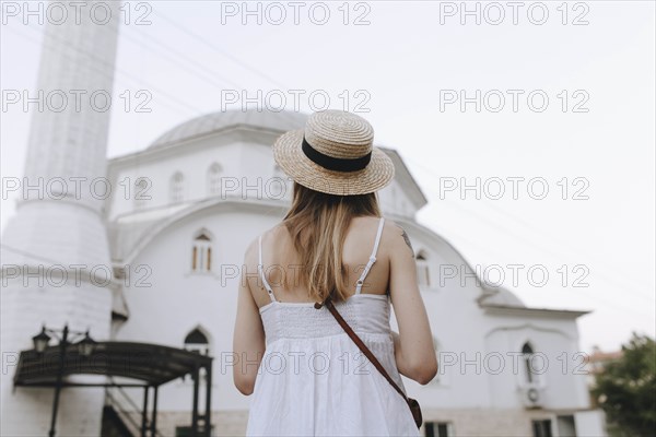 Young woman in straw hat by building in Marmaris, Turkey