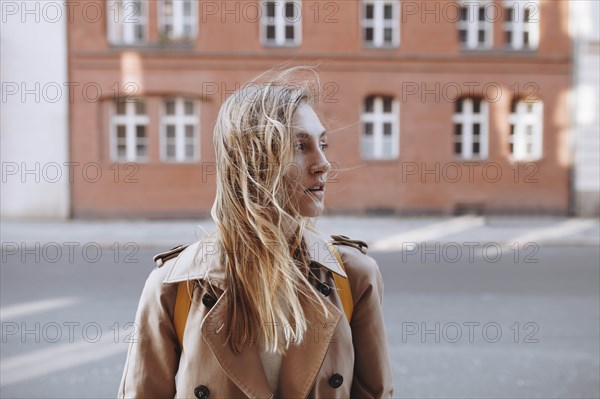 Young woman by brick building