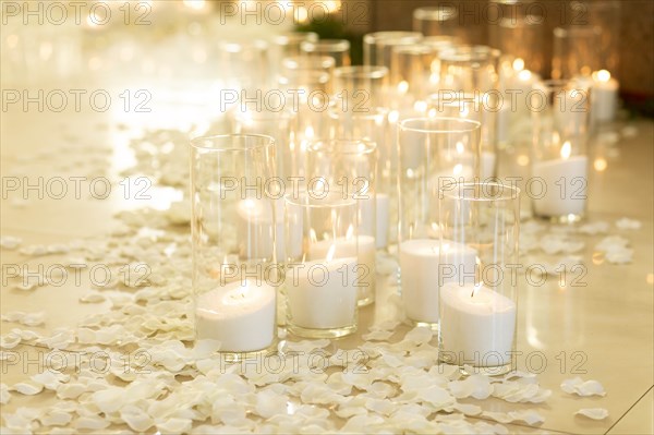 Lit white candles and petals