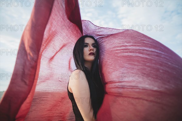 Young woman with windswept red scarf