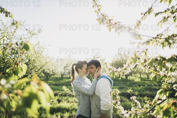 Young couple embracing by trees