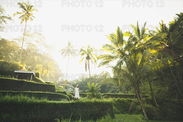 Woman wearing white dress on terraced rice paddies in Bali, Indonesia