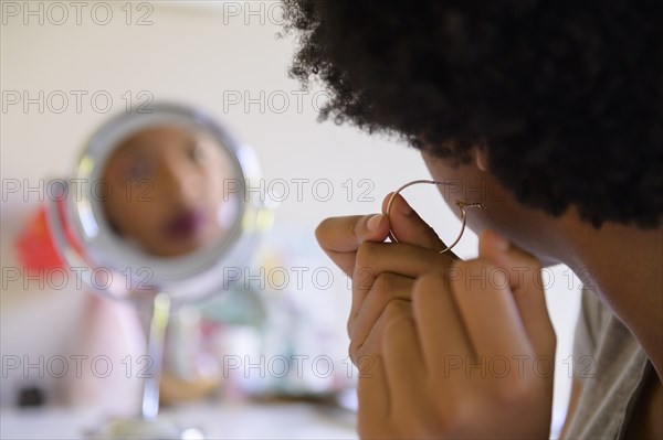 Woman putting on hoop earring