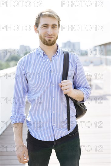 Bearded man wearing striped shirt and backpack