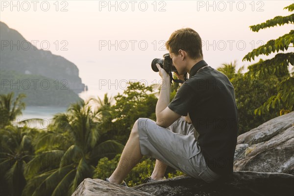 Man photographing palm trees on Phi Phi Islands, Thailand