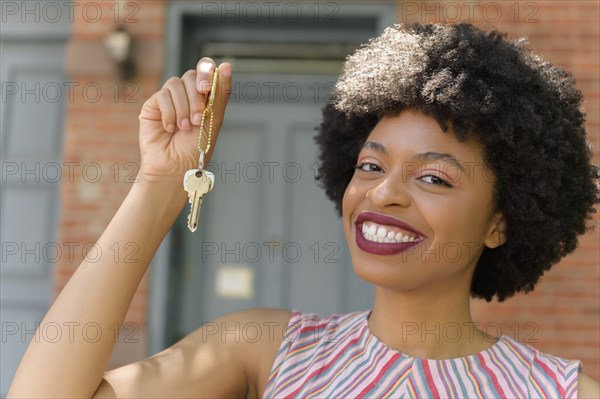 Smiling young woman holding keys
