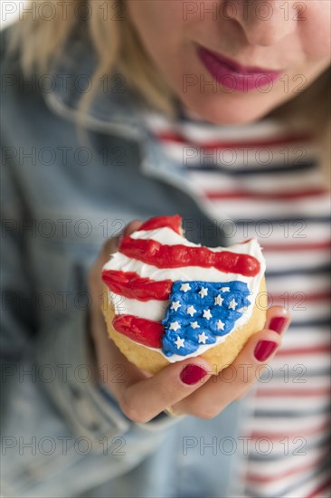 Woman holding American flag cupcake