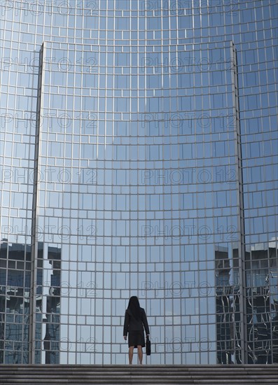 Businesswoman by reflective office building