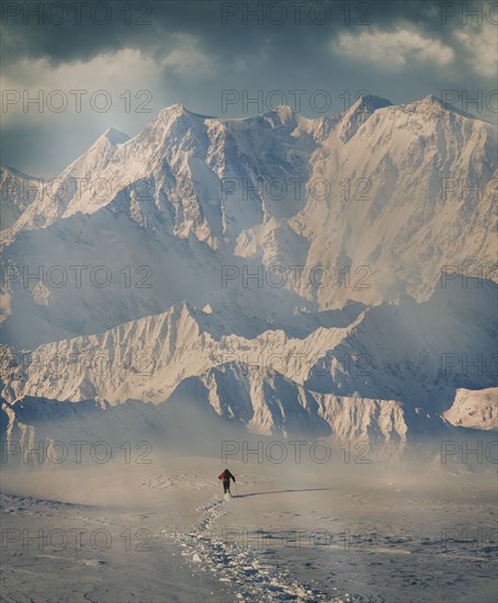 Man hiking through snow by mountain in Alpe Devero, Italy