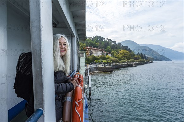 Mature woman smiling on ferry on Lake Como, Italy