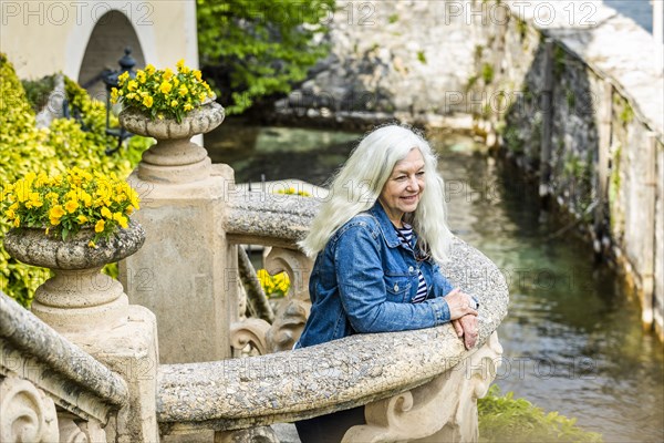 Woman on balcony of Villa del Balbianello by Lake Como, Italy