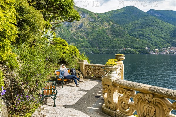 Woman on park bench at Villa del Balbianello by Lake Como, Italy