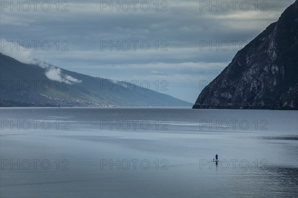 Man paddleboarding on Lake Garda, Italy