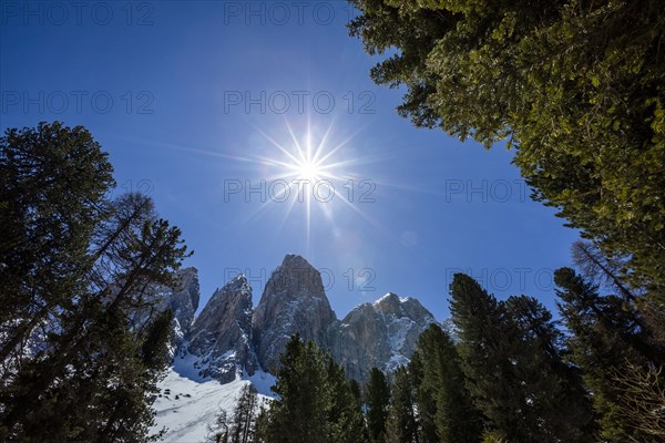 Sun over mountain range in Dolomites, Italy