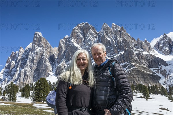 Smiling couple by mountain in Dolomites, Italy