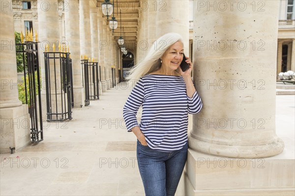 Woman on phone by columns of Palais-Royal in Paris, France