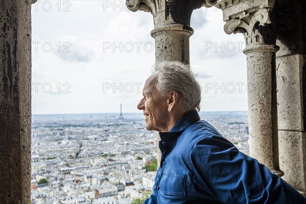 Smiling man by cityscape from Sacre Coeur in Paris, France