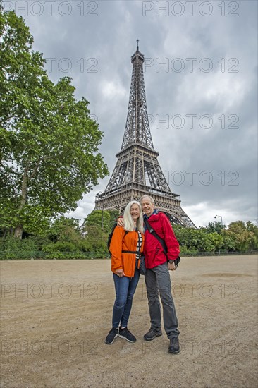 Smiling couple by Eiffel Tower in Paris, France