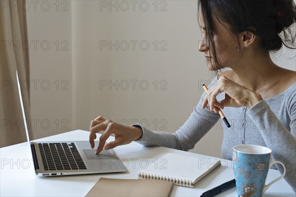 Woman using laptop working at home