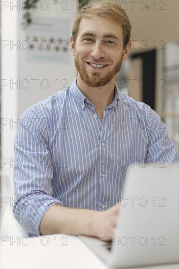 Smiling man using laptop