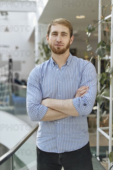 Man wearing striped shirt with his arms crossed