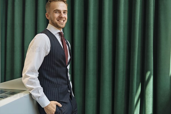 Smiling man wearing pinstripe waistcoat in store