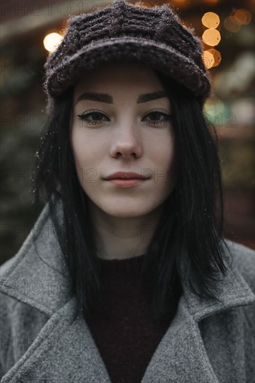 Portrait of young woman wearing woolly hat and eyeliner