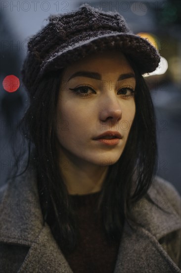 Portrait of young woman wearing woolly hat and eyeliner