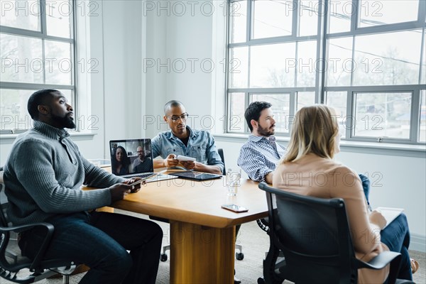Coworkers in boardroom during video call
