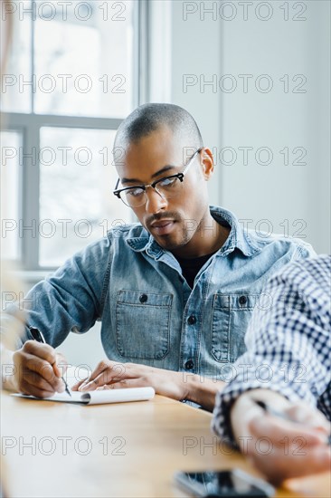 Man using note pad during meeting