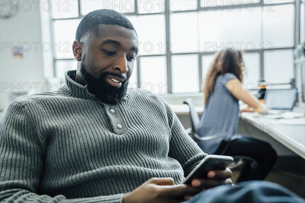 Man using smart phone in office