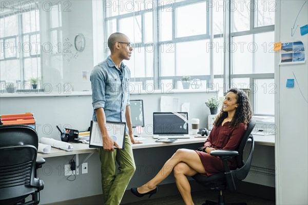 Coworkers talking in office