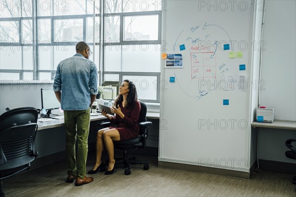 Coworkers talking in office