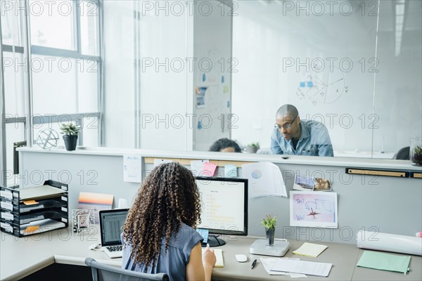 Woman using computer and laptop in office