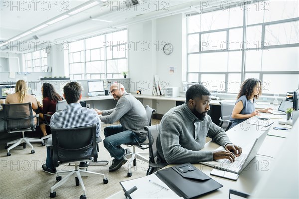 Workers using computers in office